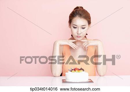 a woman with a cake in front of her View Large Photo Image Stock Photograph - a woman with a cake in front of her. Fotosearch