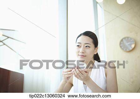 a woman with a white shirt drinking coffee View Large Photo Image Picture - a woman with a white shirt drinking coffee. Fotosearch