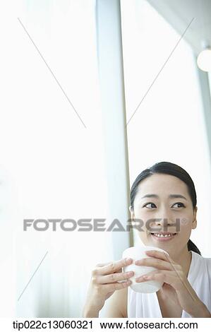 a woman with a white shirt drinking coffee View Large Photo Image Stock Image - a woman with a white shirt drinking coffee. Fotosearch
