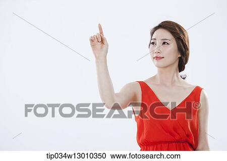 Stock Image - a woman with an orange dress posing. Fotosearch