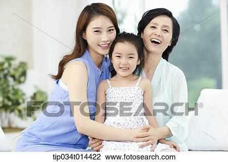 Stock Image - a woman with daughter and grand daughter on a couch. Fotosearch