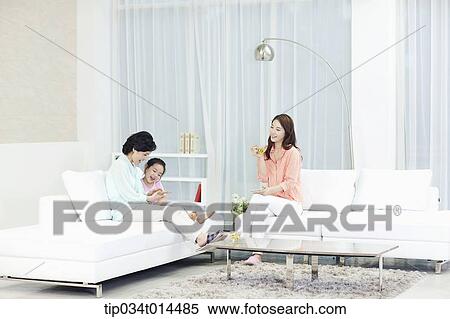 Stock Photography - a woman with daughter and grand daughter in the living room . Fotosearch