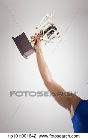 Stock Image - an arm holding a trophy. Fotosearch