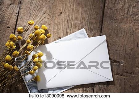 an envelop and picture with flowers on wooden surface View Large Photo Image Stock Photo - an envelop and picture with flowers on wooden surface. Fotosearch