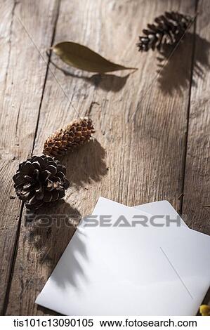 an envelop and pine cones on wooden surface View Large Photo Image Stock Photography - an envelop and pine cones on wooden surface. Fotosearch
