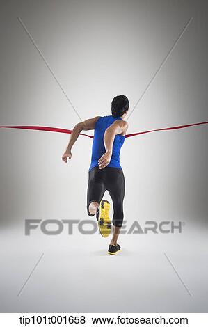 back shot of a fit man in blue shirt running to a finishing line View Large Photo Image Stock Photo - back shot of a fit man in blue shirt running to a finishing line. Fotosearch