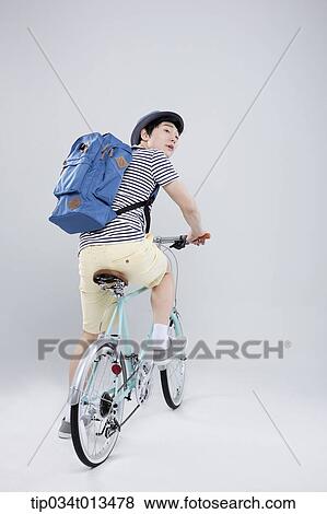 Stock Photo - back shot of a man riding a bike. Fotosearch