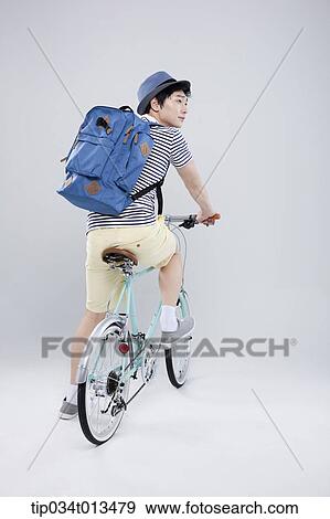 Stock Photo - back shot of a man riding a bike. Fotosearch