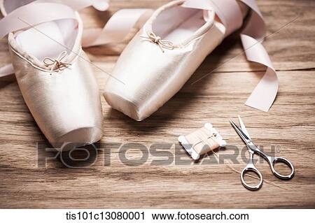 Stock Image - ballet shoes with scissors and strings on a wooden floor. Fotosearch