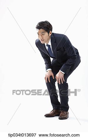 Stock Photo - businessman bending down to see something. Fotosearch