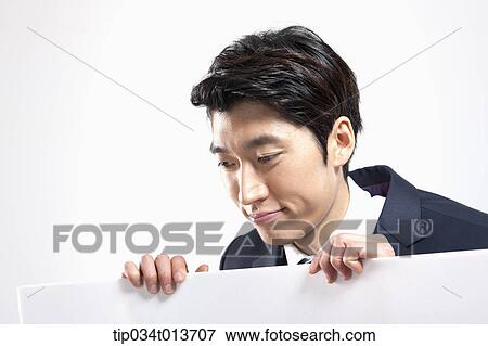 Stock Photo - businessman looking over a empty board. Fotosearch