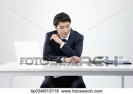 businessman sitting at a desk with a laptop View Large Photo Image Stock Photograph - businessman sitting at a desk with a laptop. Fotosearch