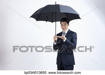 businessman with black umbrella holding something in the hand View Large Photo Image Stock Image - businessman with black umbrella holding something in the hand. Fotosearch