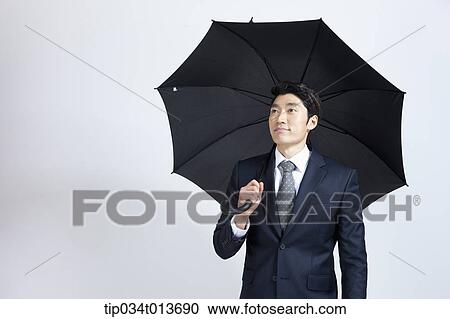 Stock Image - businessman with black umbrella. Fotosearch