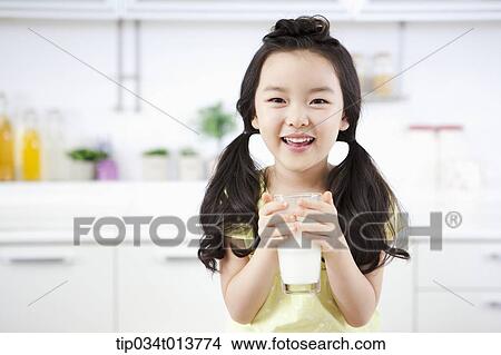 Picture - close up shot of a kid with a glass of milk. Fotosearch