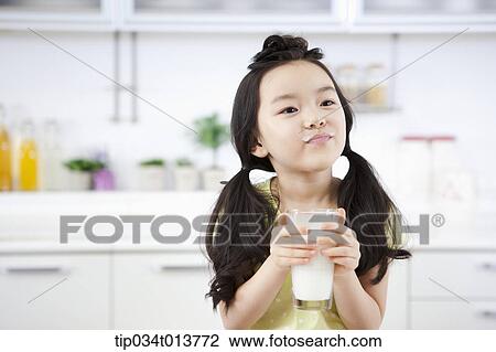 Stock Image - close up shot of a kid with a glass of milk. Fotosearch