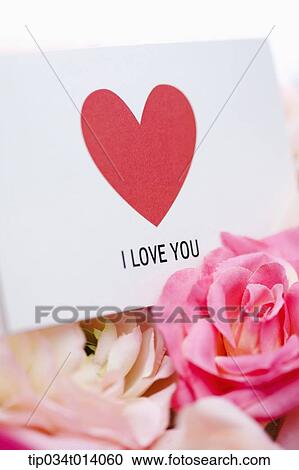 Stock Image - close up shot of a love letter and flowers. Fotosearch