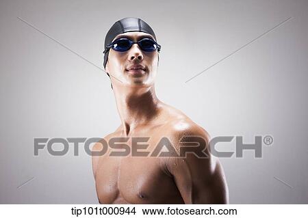Picture - close up shot of a man with swimming goggle and hat. Fotosearch