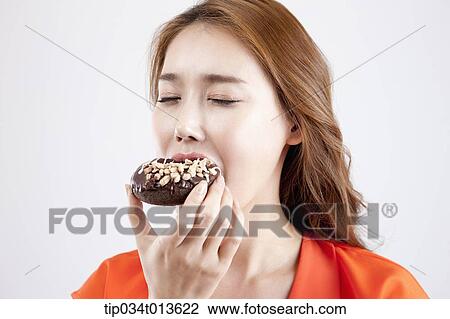 close up shot of a woman eating chocolate doughnut View Large Photo Image Stock Image - close up shot of a woman eating chocolate doughnut. Fotosearch