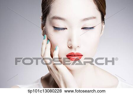 Stock Photo - close up shot of a woman in red lips with eyes closed. Fotosearch