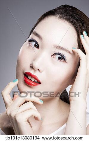 Picture - close up shot of a woman in red lipsticks and white top. Fotosearch