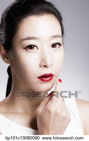 Stock Image - close up shot of a woman in red lipsticks and white top. Fotosearch