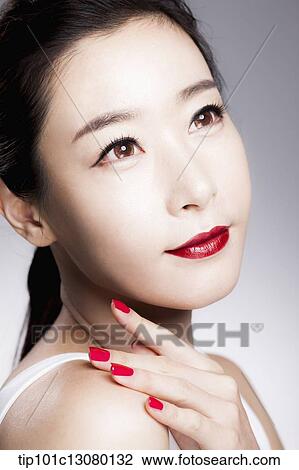 Stock Image - close up shot of a woman in red lipsticks and white top. Fotosearch
