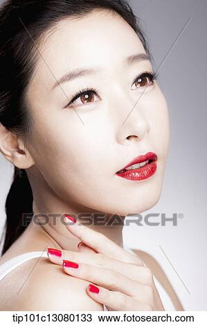 Stock Image - close up shot of a woman in red lipsticks and white top. Fotosearch