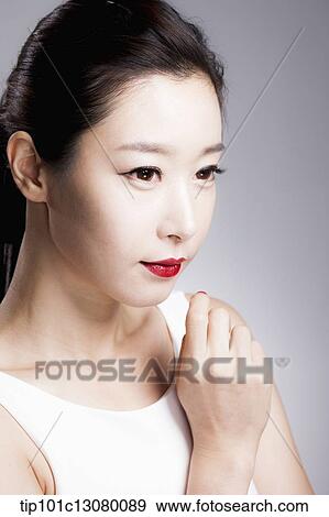 Stock Photo - close up shot of a woman in red lipsticks and white top. Fotosearch