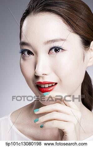 Stock Photo - close up shot of a woman in red lipsticks and white top. Fotosearch