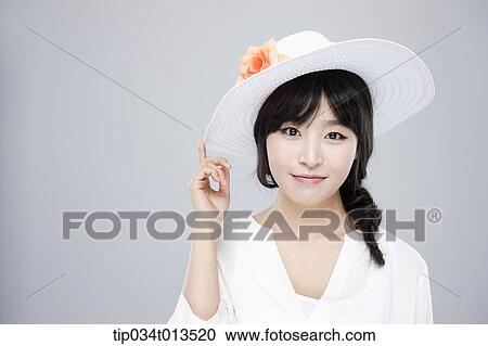 Stock Image - close up shot of a woman in white hat posing . Fotosearch