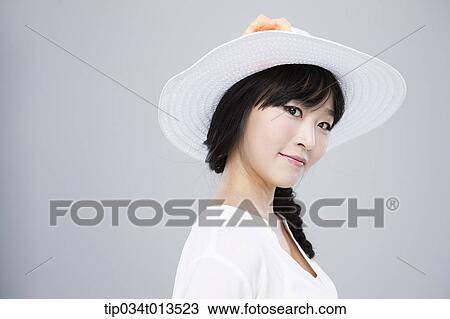 Stock Image - close up shot of a woman in white hat posing . Fotosearch