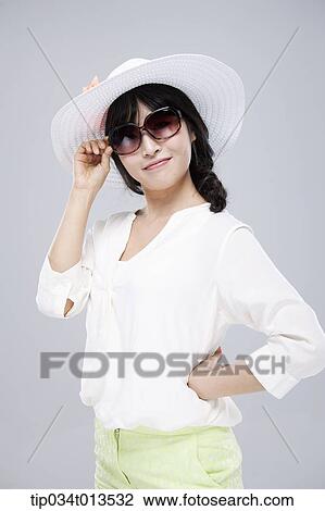 Stock Image - close up shot of a woman in white hat and sunglasses. Fotosearch