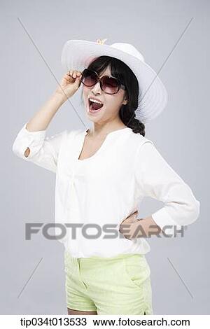Stock Image - close up shot of a woman in white hat and sunglasses. Fotosearch