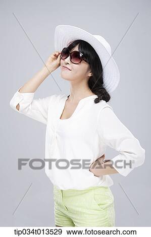 Stock Photo - close up shot of a woman in white hat and sunglasses. Fotosearch