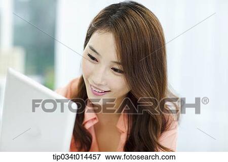 Stock Photo - close up shot of a woman using tablet PC. Fotosearch