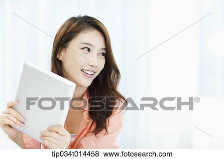 Stock Photo - close up shot of a woman using tablet PC. Fotosearch