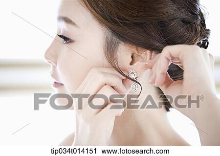 Stock Image - close up shot of a woman wearing earring. Fotosearch