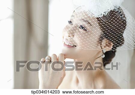 Stock Image - close up shot of a woman wearing wedding veils. Fotosearch