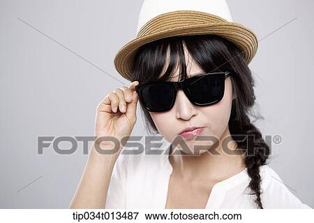close up shot of a woman with a hat posing with sunglasses View Large Photo Image Stock Photo - close up shot of a woman with a hat posing with sunglasses. Fotosearch