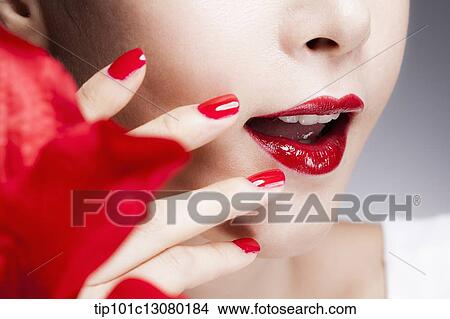 close up shot of a woman's red nails on a face with red lips View Large Photo Image Picture - close up shot of a woman's red nails on a face with red lips. Fotosearch