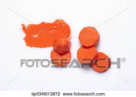 Stock Image - close up shot of broken orange lipstick . Fotosearch