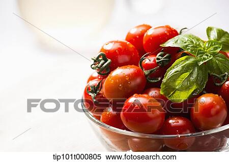 Stock Photography - close up shot of sweet pea tomatoes in a glass bowl. Fotosearch