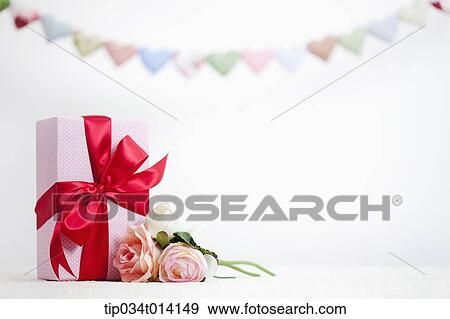 Stock Photo - different colors of heart shapes along each other above flower and gifts. Fotosearch