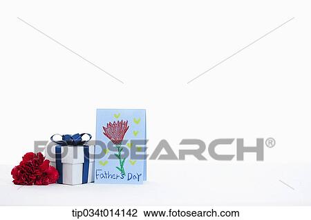 Stock Image - flower and gift box next to father's day card . Fotosearch