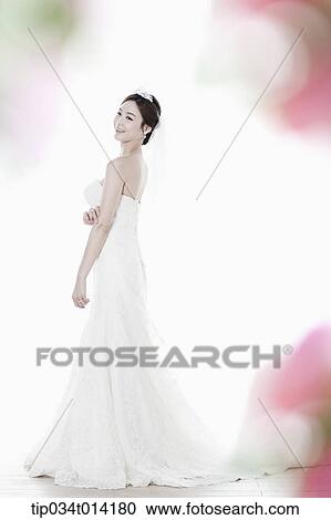Stock Image - full shot of a woman in wedding dress. Fotosearch