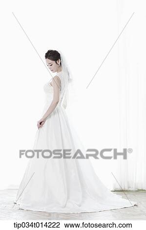 Stock Image - full shot of a woman in wedding dress. Fotosearch
