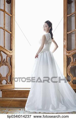 Stock Photo - full shot of a woman in wedding dress stepping up the stairs. Fotosearch