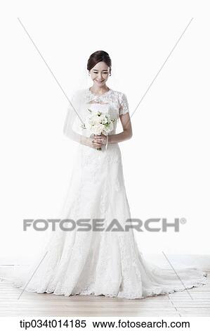 full shot of a woman in wedding dress holding flower bouquet View Large Photo Image Stock Photography - full shot of a woman in wedding dress holding flower bouquet. Fotosearch