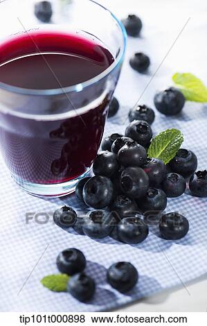 Stock Photo - glass of berry juice with blue berries . Fotosearch